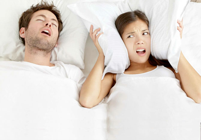 Pareja en cama con problemas de ronquido